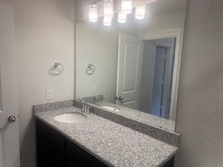 bathroom featuring vanity and a textured wall