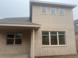 back of house featuring brick siding