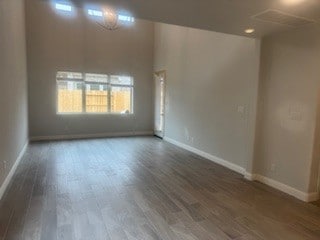 unfurnished room featuring baseboards and wood finished floors