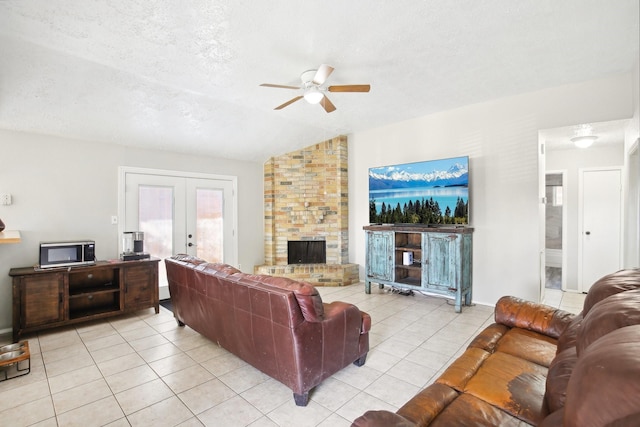 living area featuring light tile patterned floors, french doors, a large fireplace, and a textured ceiling