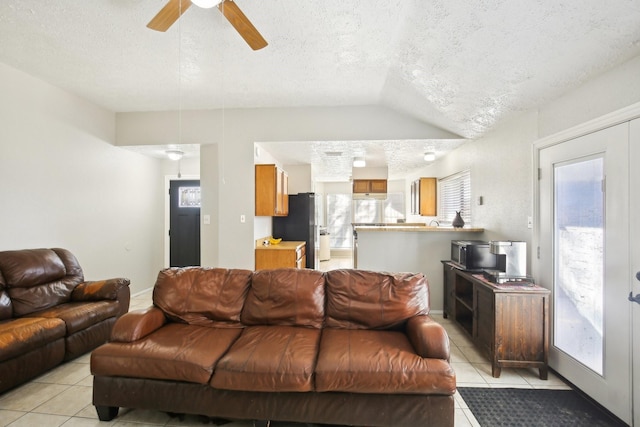 living area with light tile patterned floors, plenty of natural light, and lofted ceiling