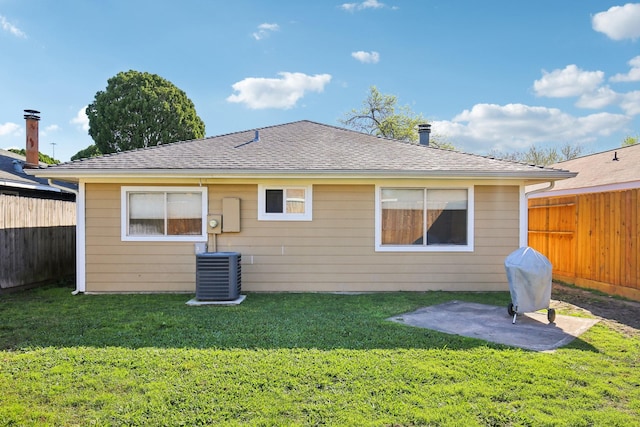 rear view of property with cooling unit, a fenced backyard, and a yard