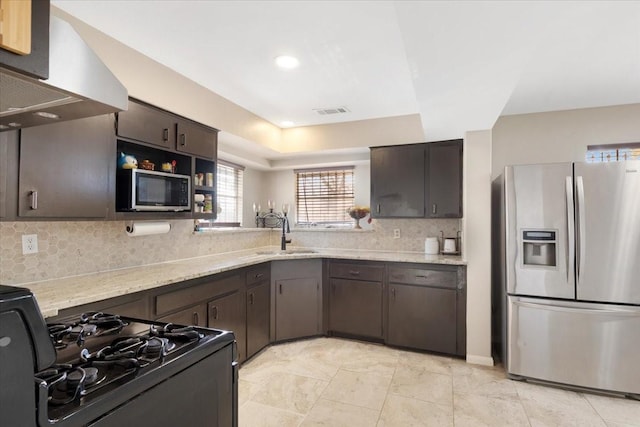 kitchen featuring visible vents, a sink, range hood, stainless steel appliances, and dark brown cabinetry