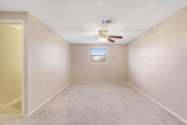 empty room with visible vents, carpet flooring, a textured ceiling, and a textured wall