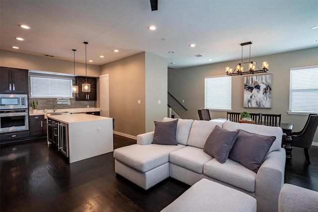 living area featuring dark wood-style floors, a notable chandelier, recessed lighting, and a healthy amount of sunlight