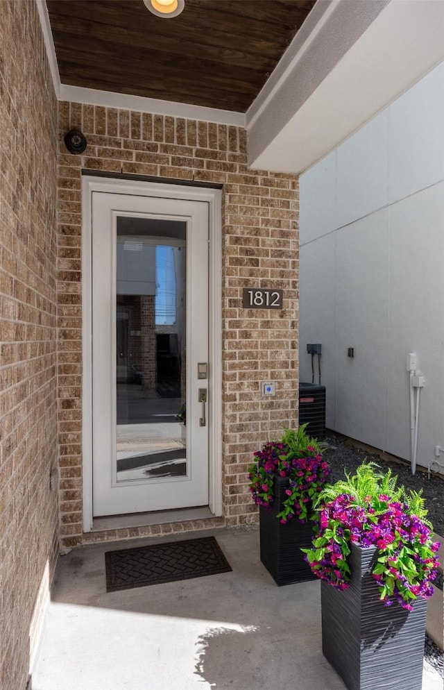 entrance to property with brick siding and central AC