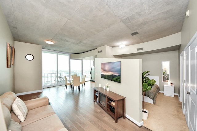 living area with visible vents, baseboards, and light wood-style floors