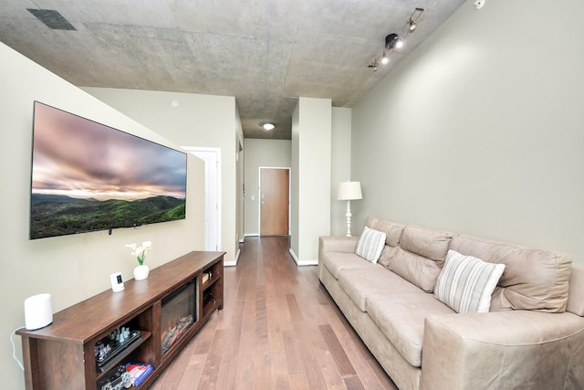 living room with wood finished floors, visible vents, and baseboards