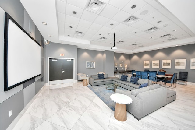 home theater featuring visible vents, a raised ceiling, and marble finish floor