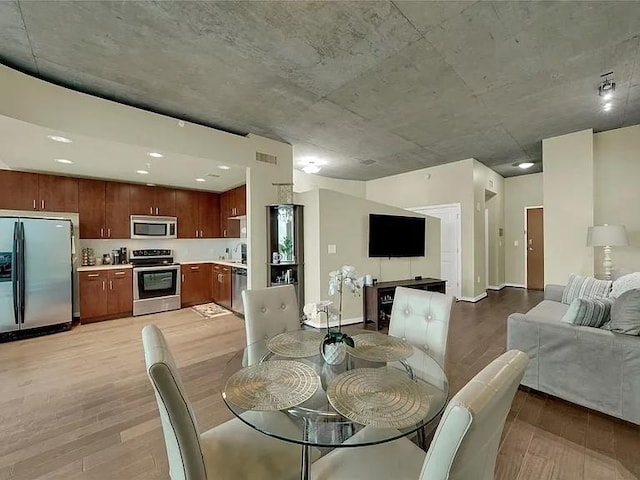 dining area with visible vents, baseboards, and light wood-style floors