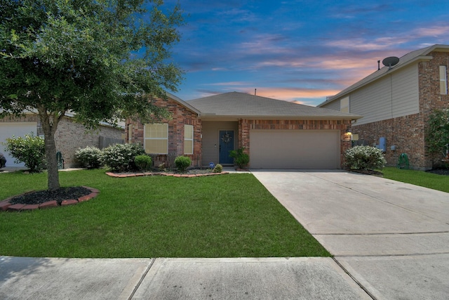 ranch-style home with brick siding, a garage, driveway, and a yard