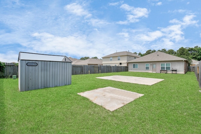 view of yard featuring an outbuilding, a fenced backyard, a storage unit, and a patio