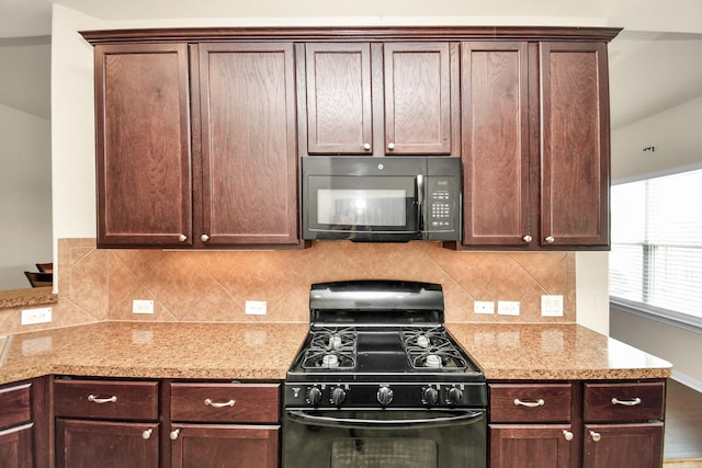 kitchen featuring dark brown cabinetry, backsplash, black appliances, and light stone countertops