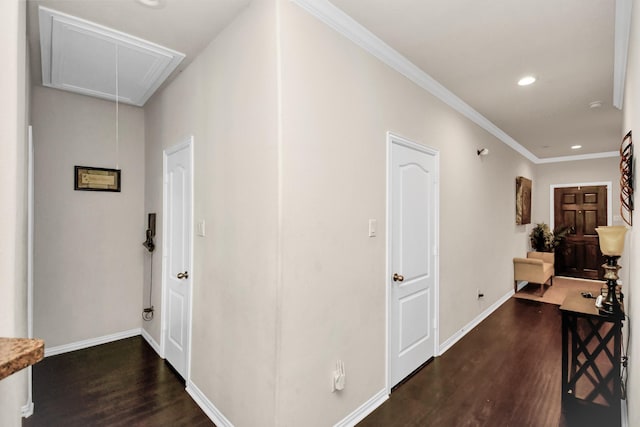 hall with attic access, crown molding, baseboards, and wood finished floors