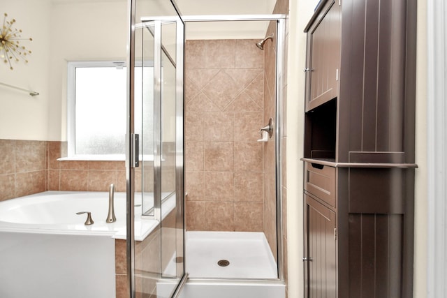 full bathroom featuring a bath and a stall shower