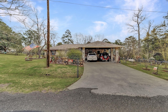 view of front facade with a front yard, fence, driveway, roof with shingles, and a carport