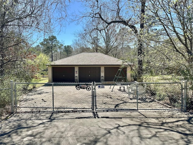 detached garage with a gate and fence