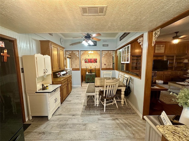 kitchen with ceiling fan, visible vents, freestanding refrigerator, and a textured ceiling