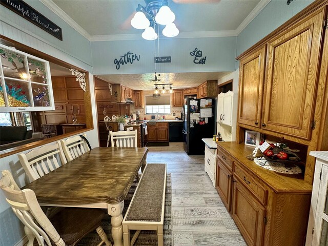 dining space with light wood-style flooring, an inviting chandelier, and ornamental molding