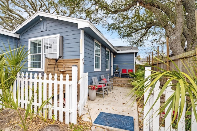 view of property exterior with a patio and fence