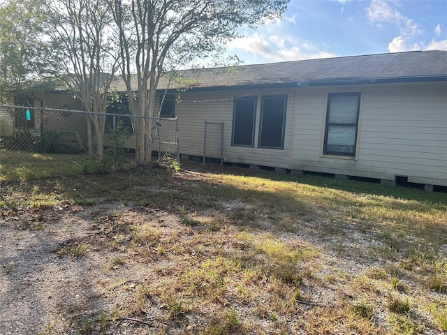 back of property with roof with shingles and fence