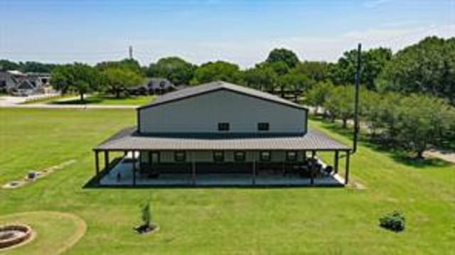 rear view of property featuring a lawn