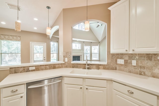 18 Valley Mead Pl, Conroe, TX 77384 - kitchen with dishwasher, decorative backsplash, vaulted ceiling, hanging light fixtures, and white cabinets