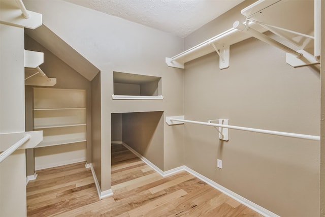 spacious closet featuring vaulted ceiling and wood finished floors