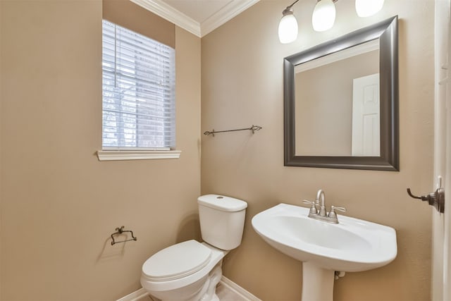 bathroom featuring a sink, toilet, baseboards, and ornamental molding