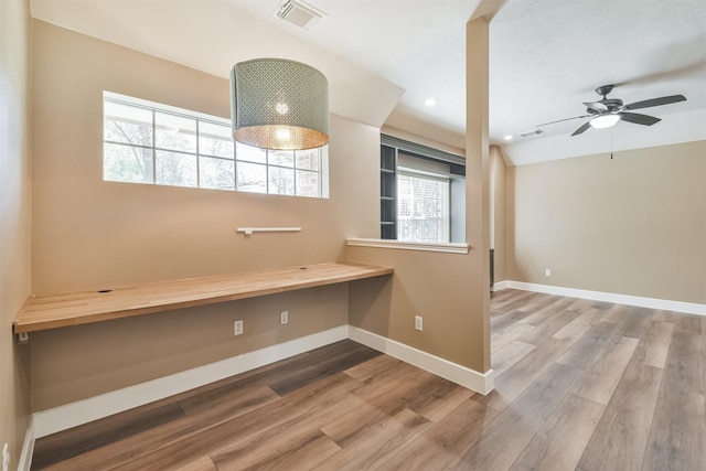 interior space featuring wood finished floors, visible vents, a wealth of natural light, and baseboards