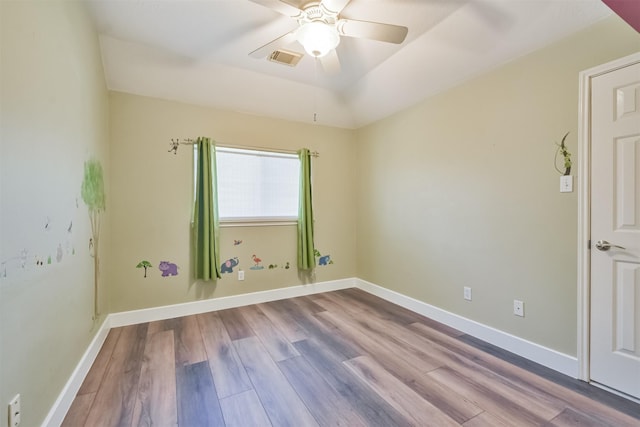 unfurnished room with visible vents, baseboards, wood finished floors, and a ceiling fan