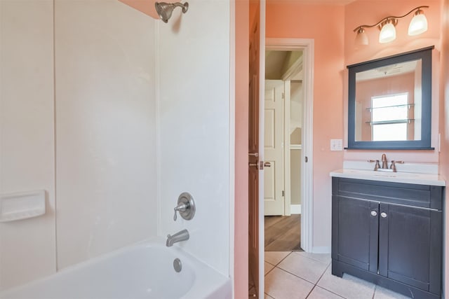 bathroom featuring tile patterned flooring, vanity, baseboards, and shower / bathtub combination