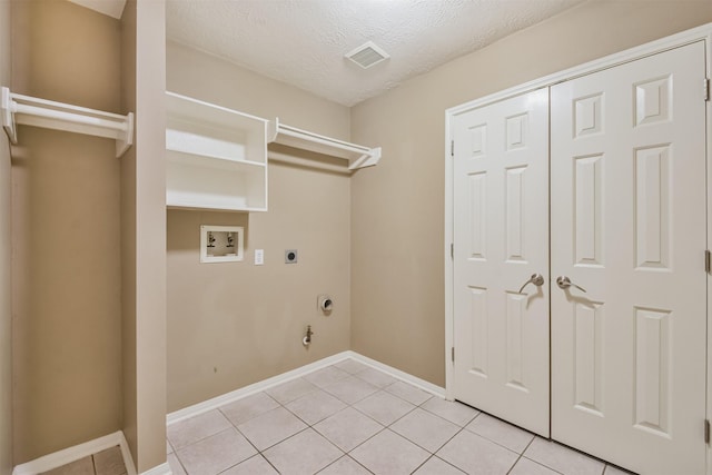 clothes washing area with visible vents, washer hookup, light tile patterned floors, laundry area, and hookup for an electric dryer