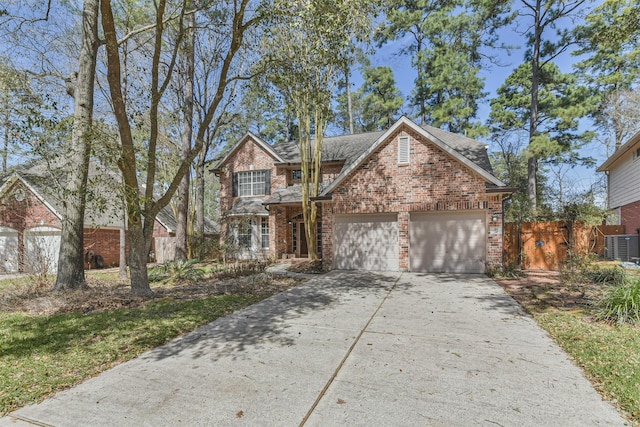 traditional home with brick siding, fence, concrete driveway, cooling unit, and a garage