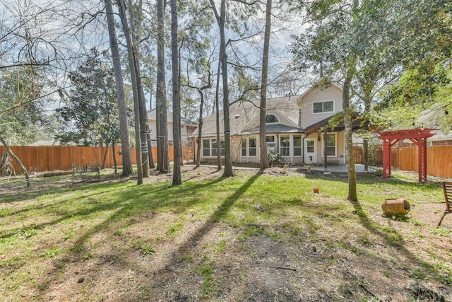 rear view of house with a yard, a patio, a pergola, and a fenced backyard