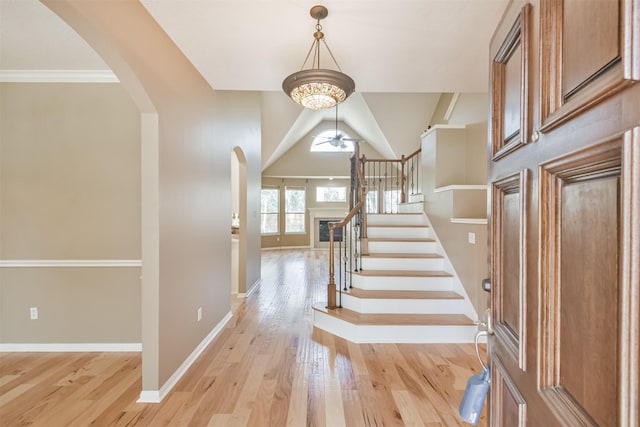 18 Valley Mead Pl, Conroe, TX 77384 - entryway featuring arched walkways, light wood finished floors, ceiling fan, stairway, and vaulted ceiling