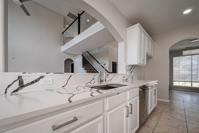 kitchen featuring visible vents, light countertops, stainless steel dishwasher, white cabinetry, and a sink