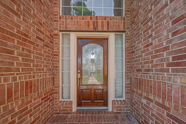 view of exterior entry with brick siding