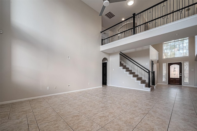 entrance foyer with visible vents, arched walkways, baseboards, and stairs