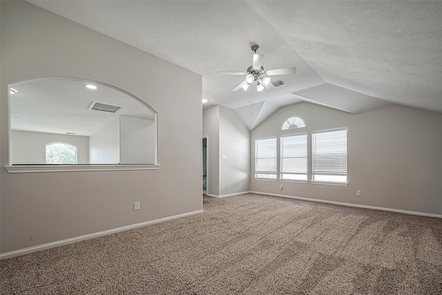 carpeted empty room featuring visible vents, baseboards, ceiling fan, lofted ceiling, and a textured ceiling