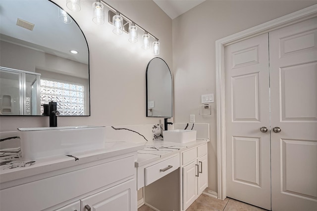 full bath featuring tile patterned flooring, double vanity, visible vents, and a sink