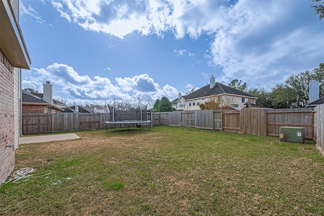 view of yard featuring a trampoline and a fenced backyard