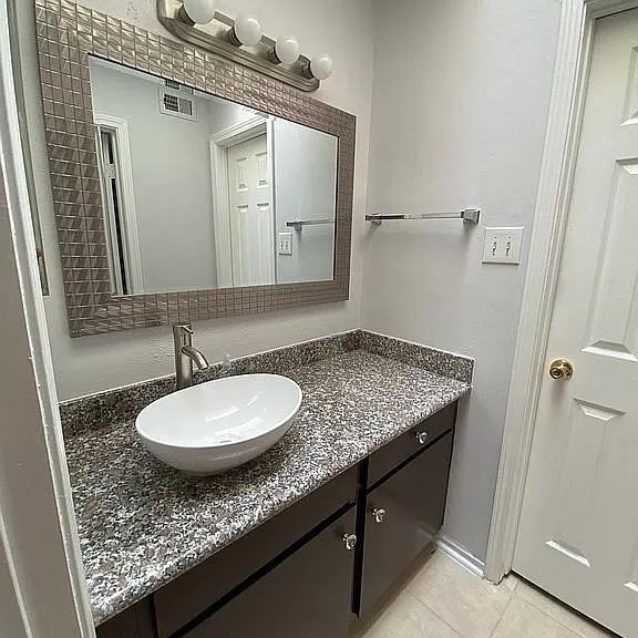 bathroom featuring tile patterned flooring, visible vents, and vanity