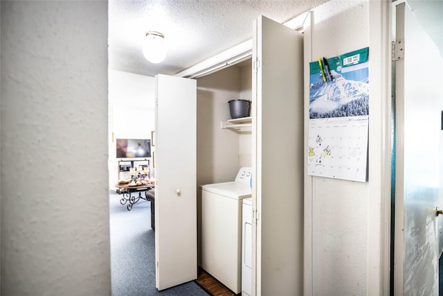 laundry room with laundry area, washing machine and clothes dryer, and a textured ceiling