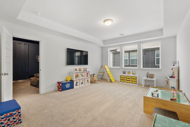 recreation room with visible vents, a raised ceiling, carpet, and baseboards