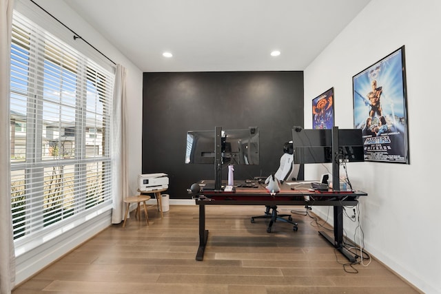 office space with recessed lighting, plenty of natural light, wood finished floors, and baseboards