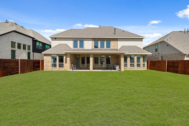 back of house with a yard, a fenced backyard, and roof with shingles