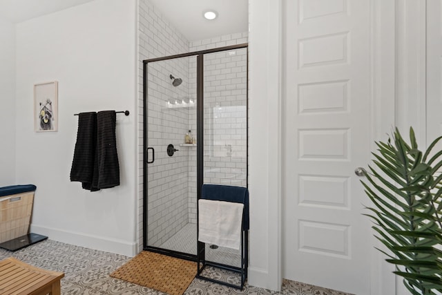 full bathroom featuring tile patterned flooring, a stall shower, and baseboards