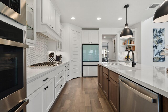 kitchen featuring visible vents, a sink, appliances with stainless steel finishes, light countertops, and dark wood-style flooring