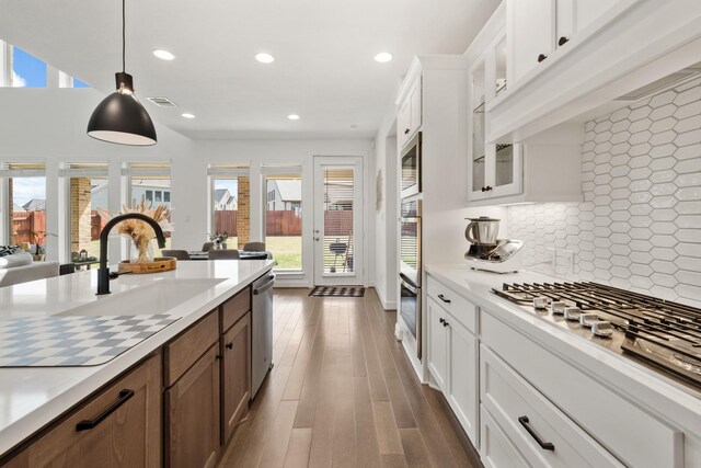 kitchen with light countertops, visible vents, backsplash, and a sink